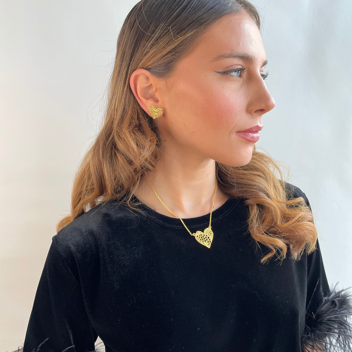 Remy lace heart necklace in 24k gold worn by a model.