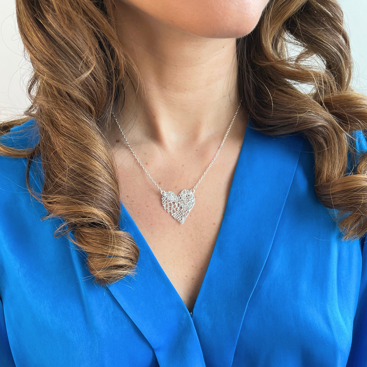 Remy lace heart necklace in sterling silver worn by a model.