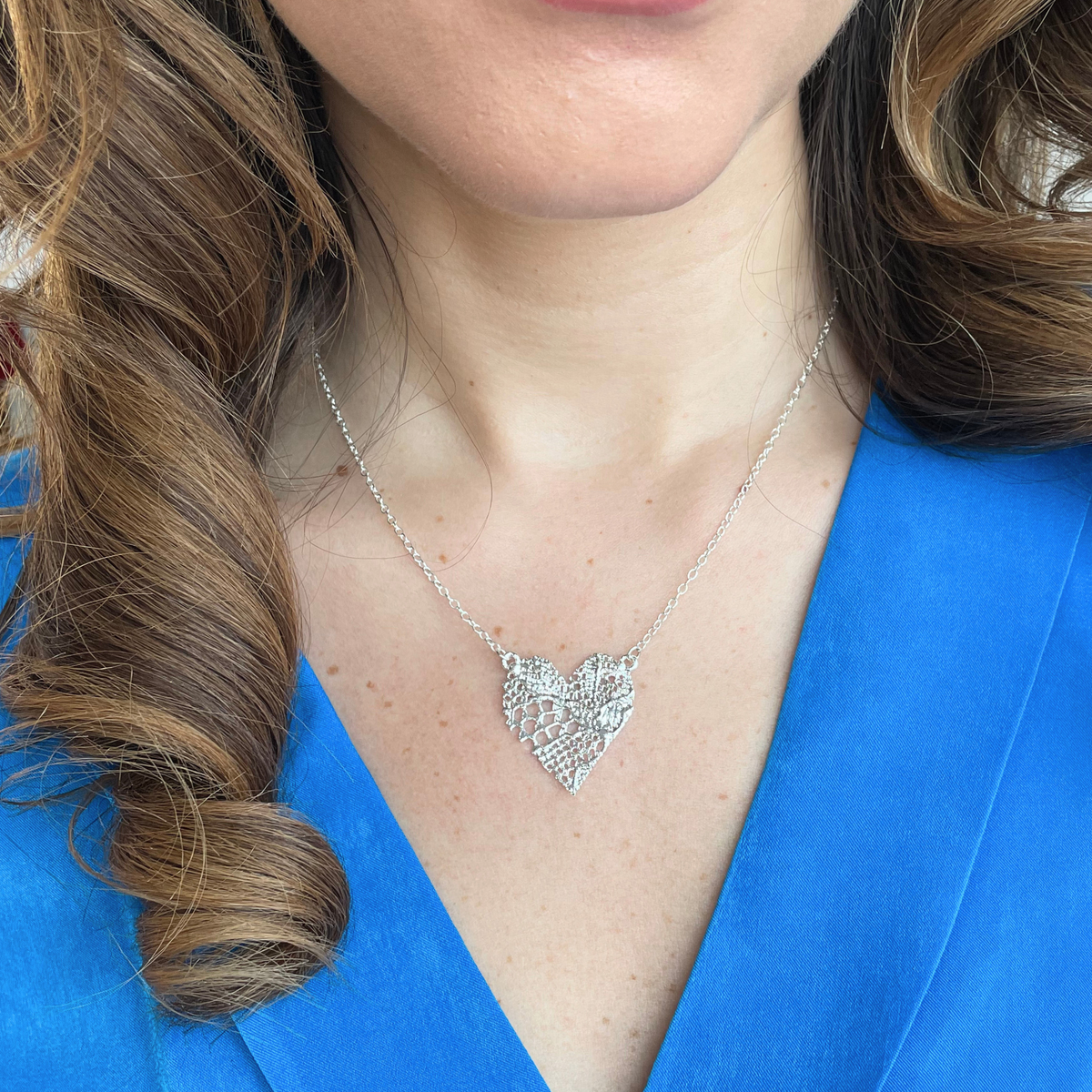 Remy lace heart necklace in sterling silver worn by a model.