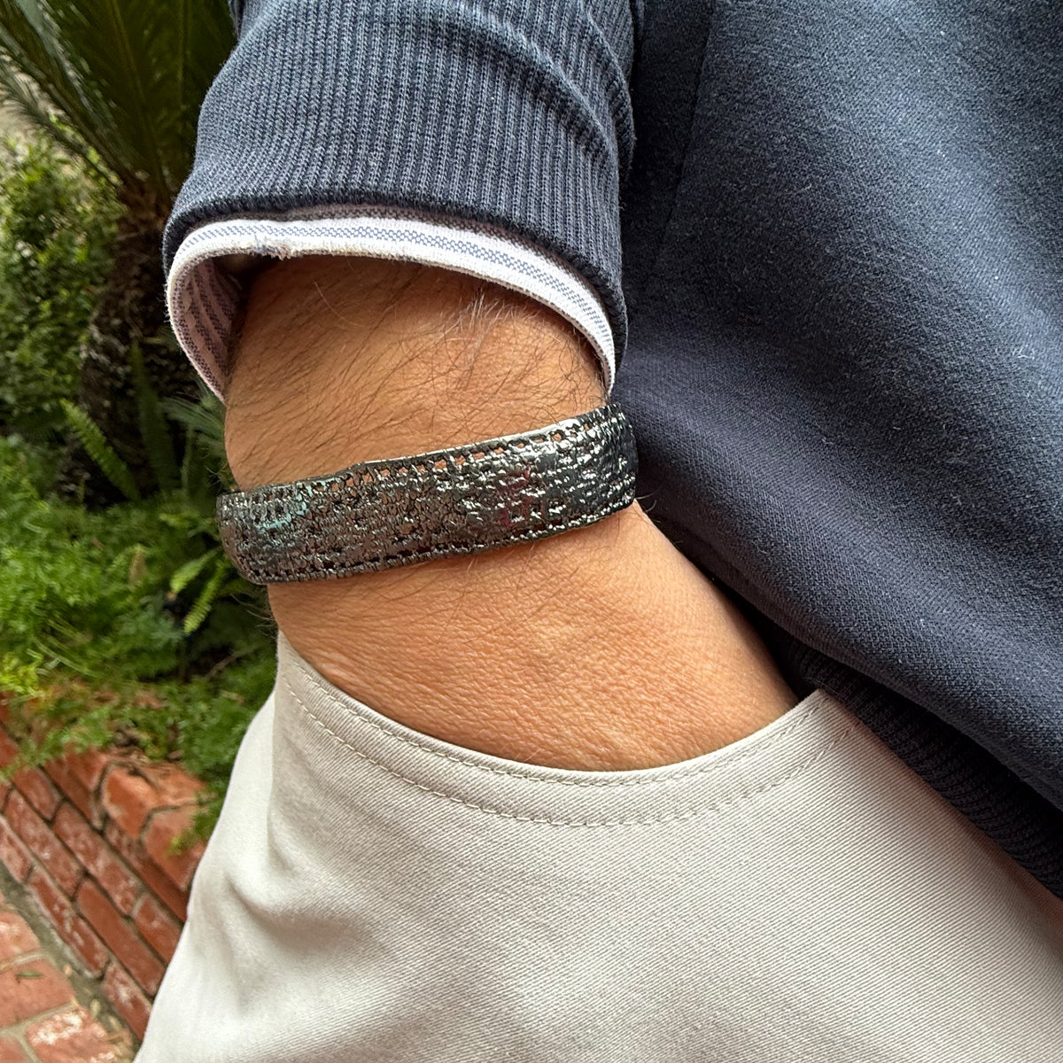 A model wearing a men's lace bracelet in dipped oxidized sterling silver.