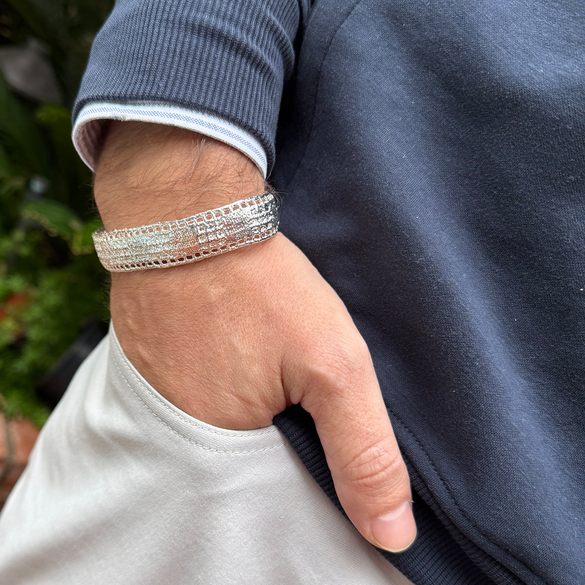 A model wearing a men's lace bracelet in dipped sterling silver.