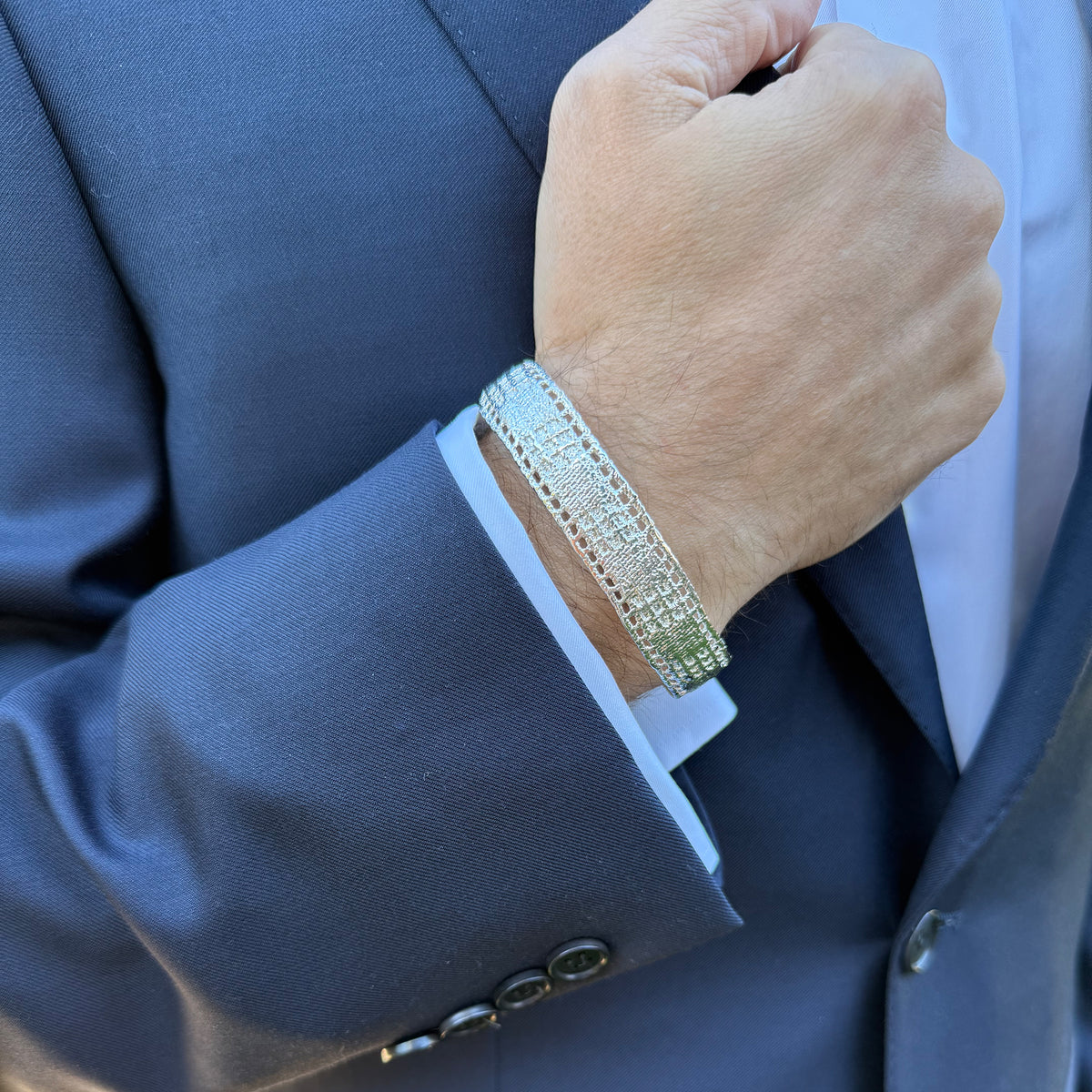 A model wearing a men's lace bracelet in dipped sterling silver.