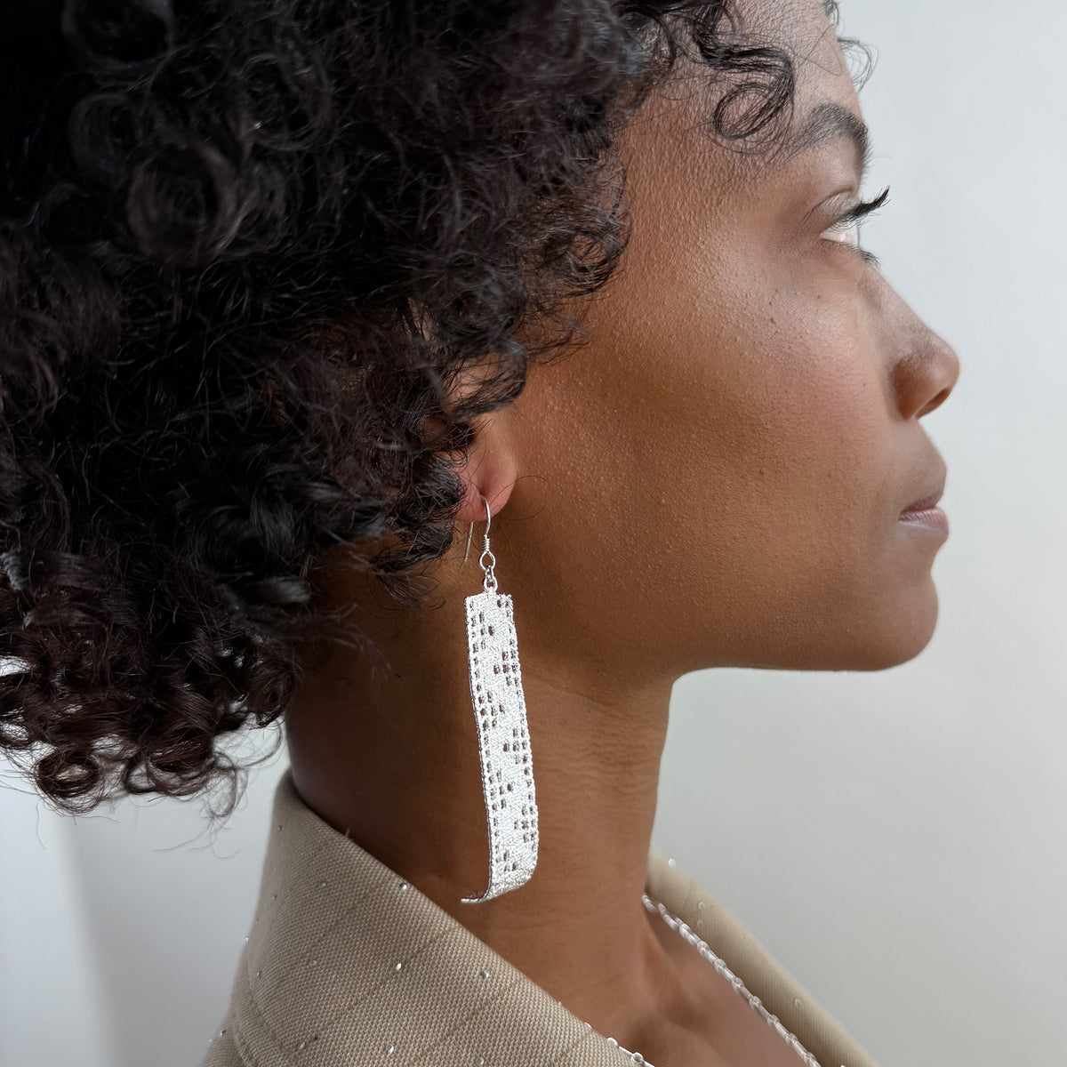 A model wearing Signe, long lace earrings in sterling silver.