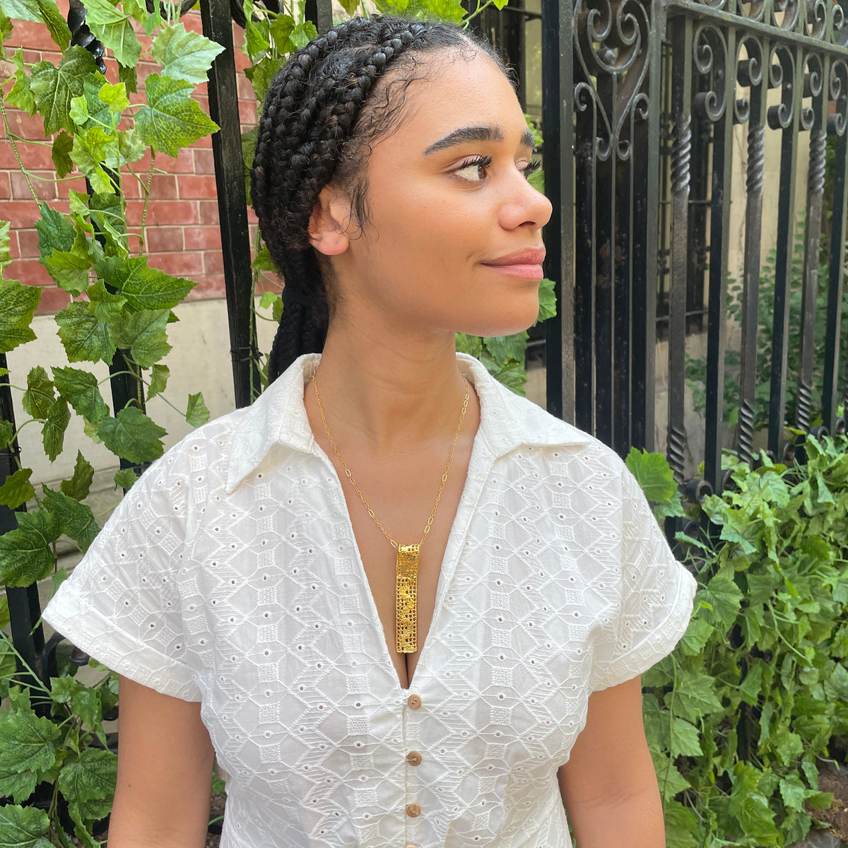 Lace pendant necklace solidified in 24k gold on model.