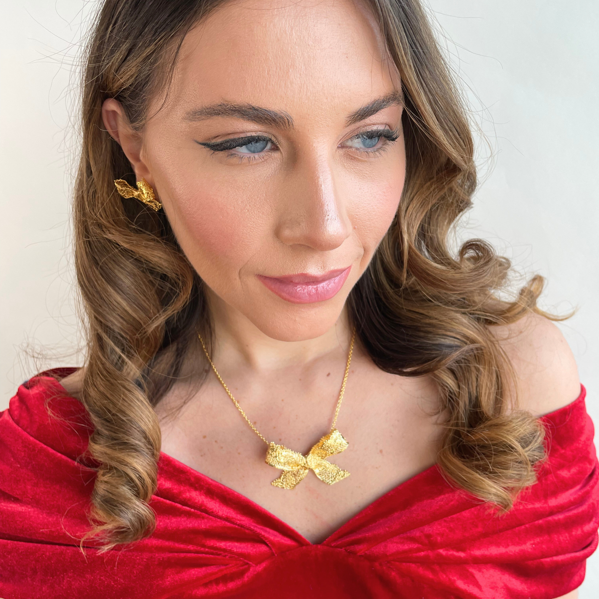 Micheline Lace Bow Necklace in 24k gold worn by a model.
