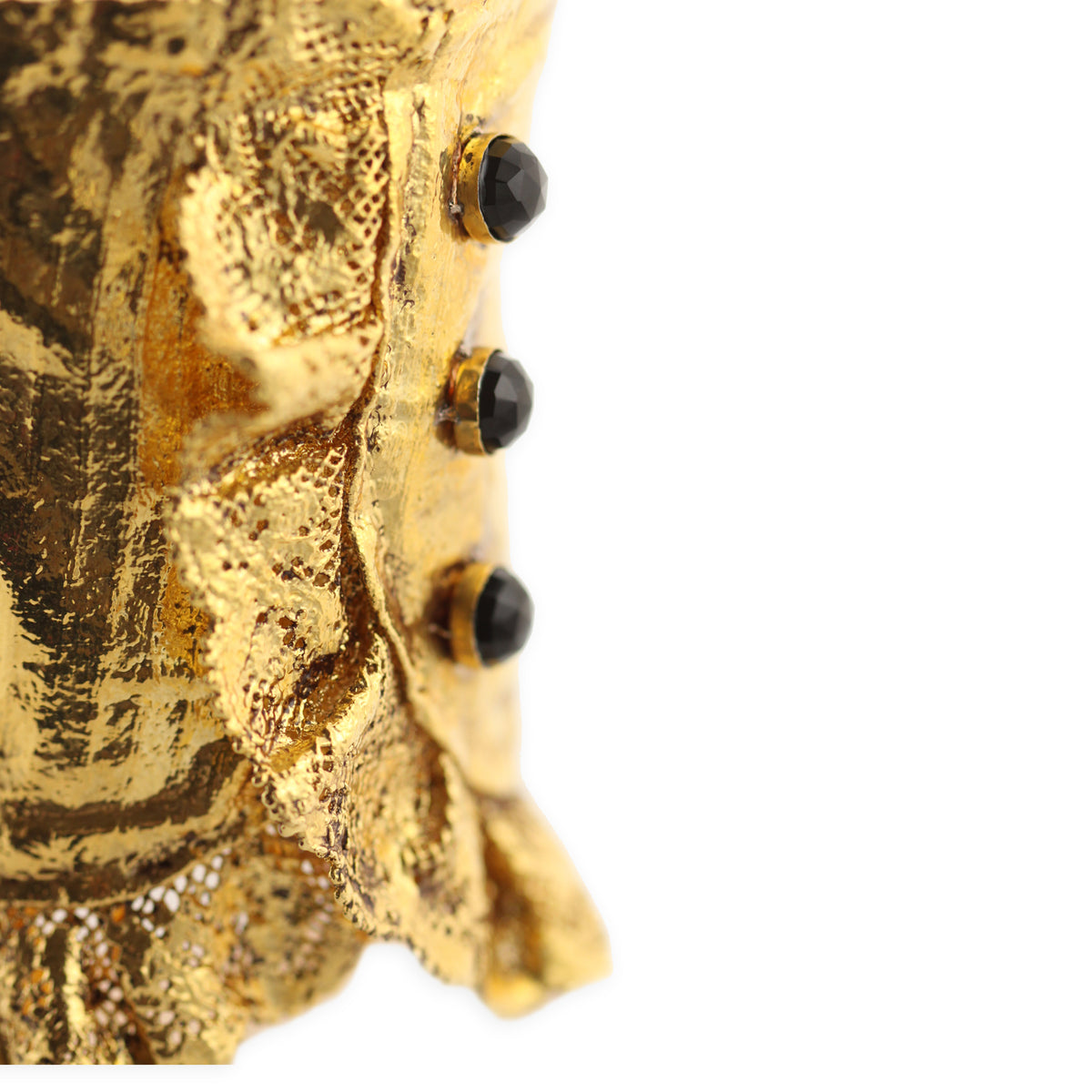 Detail from lace cuff bracelet in 24k gold with three faceted stones.