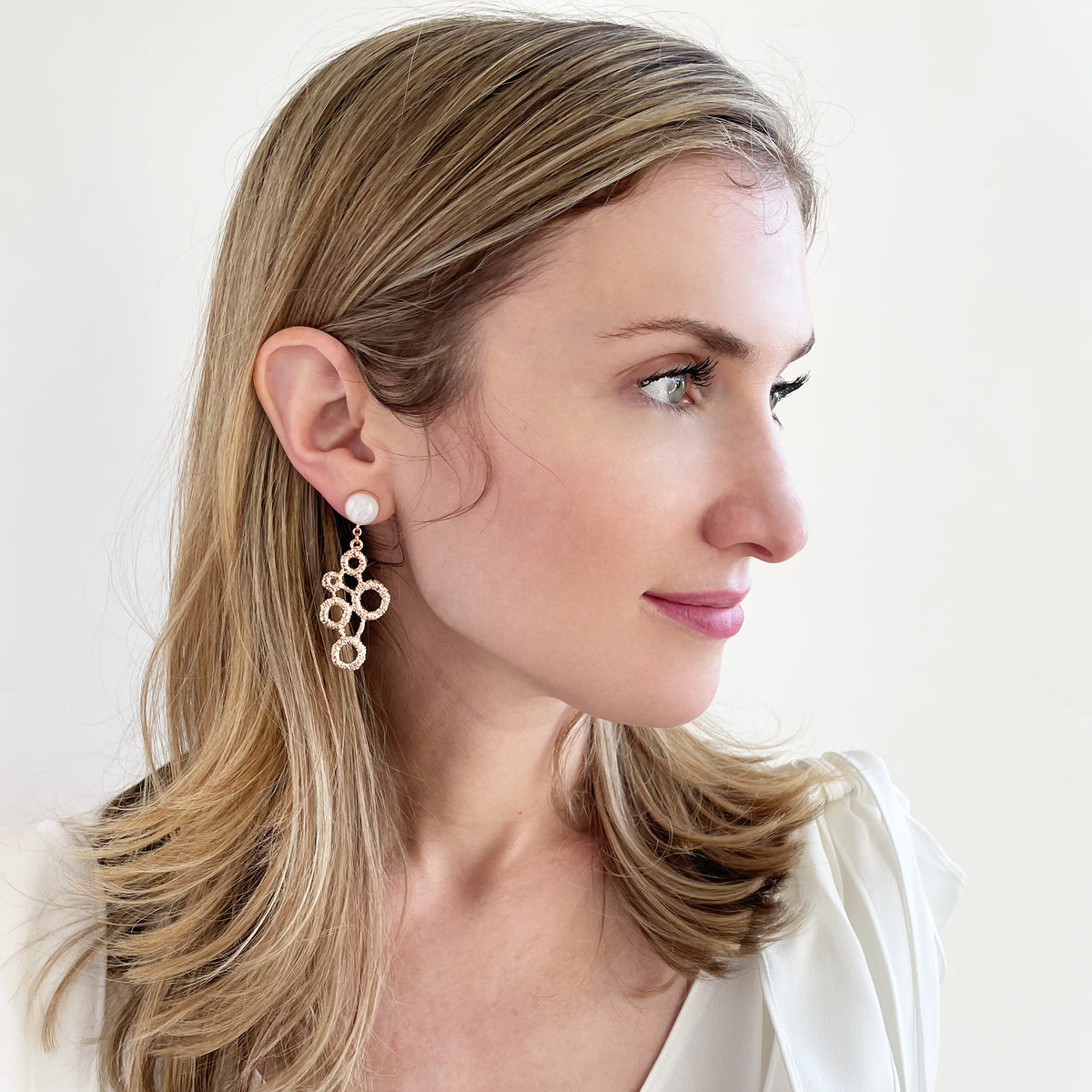 Circle lace earrings in rose gold with moonstones on a model.