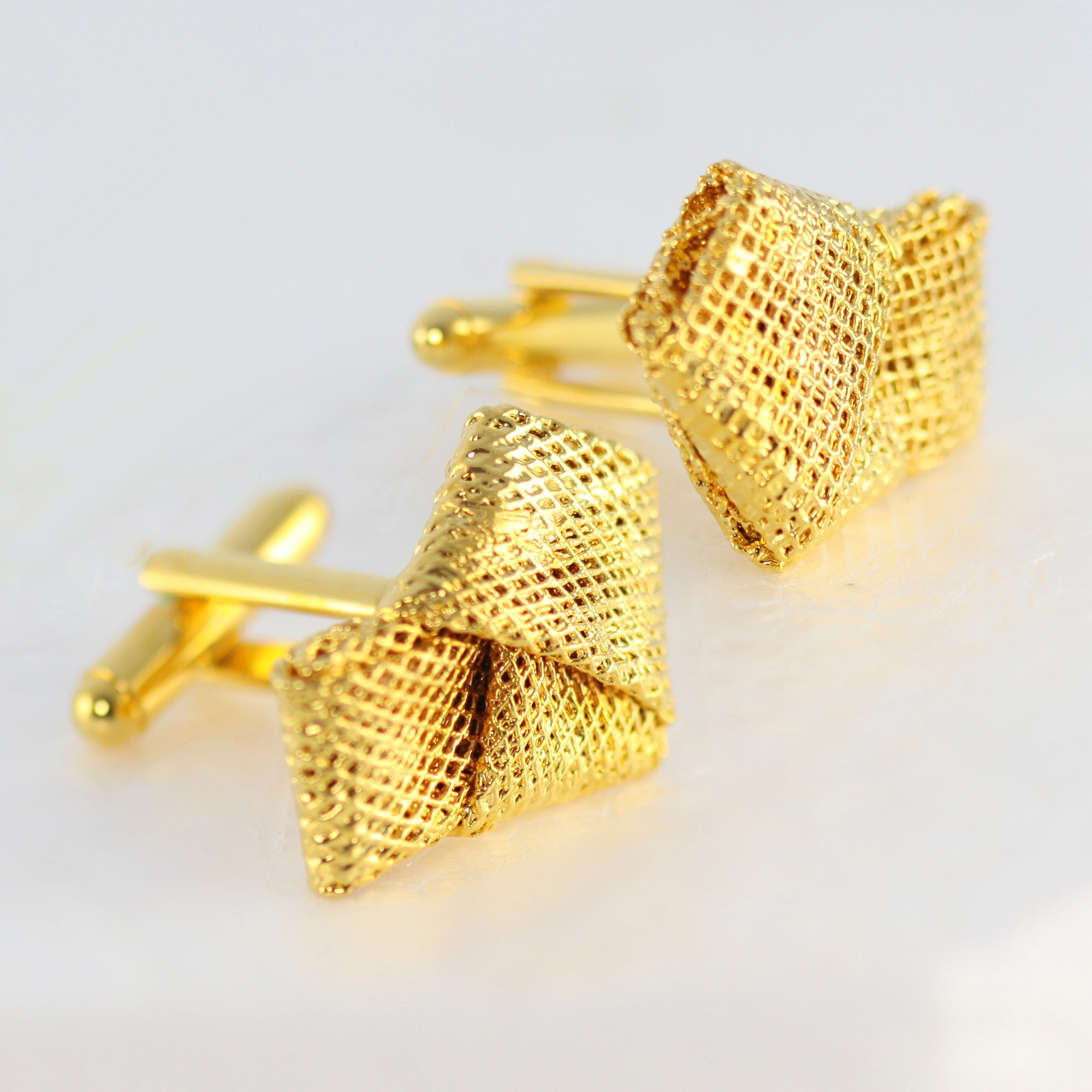 Cufflinks made from wedding dress tulle tied in a knot and dipped in 24k gold.