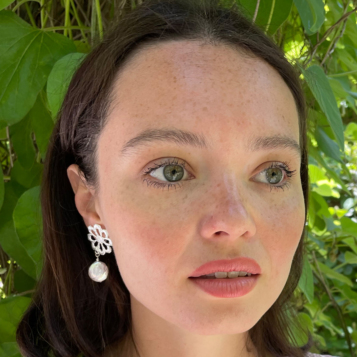 Model wearing baroque coin pearl earring with flower lace in sterling silver.