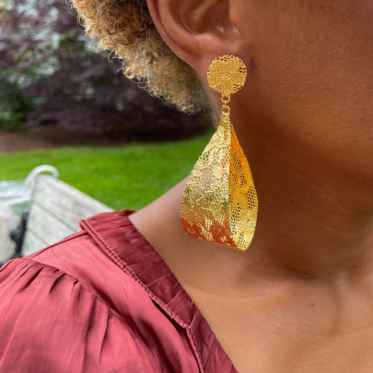 Camie lace loop earrings in 24k gold worn by model.