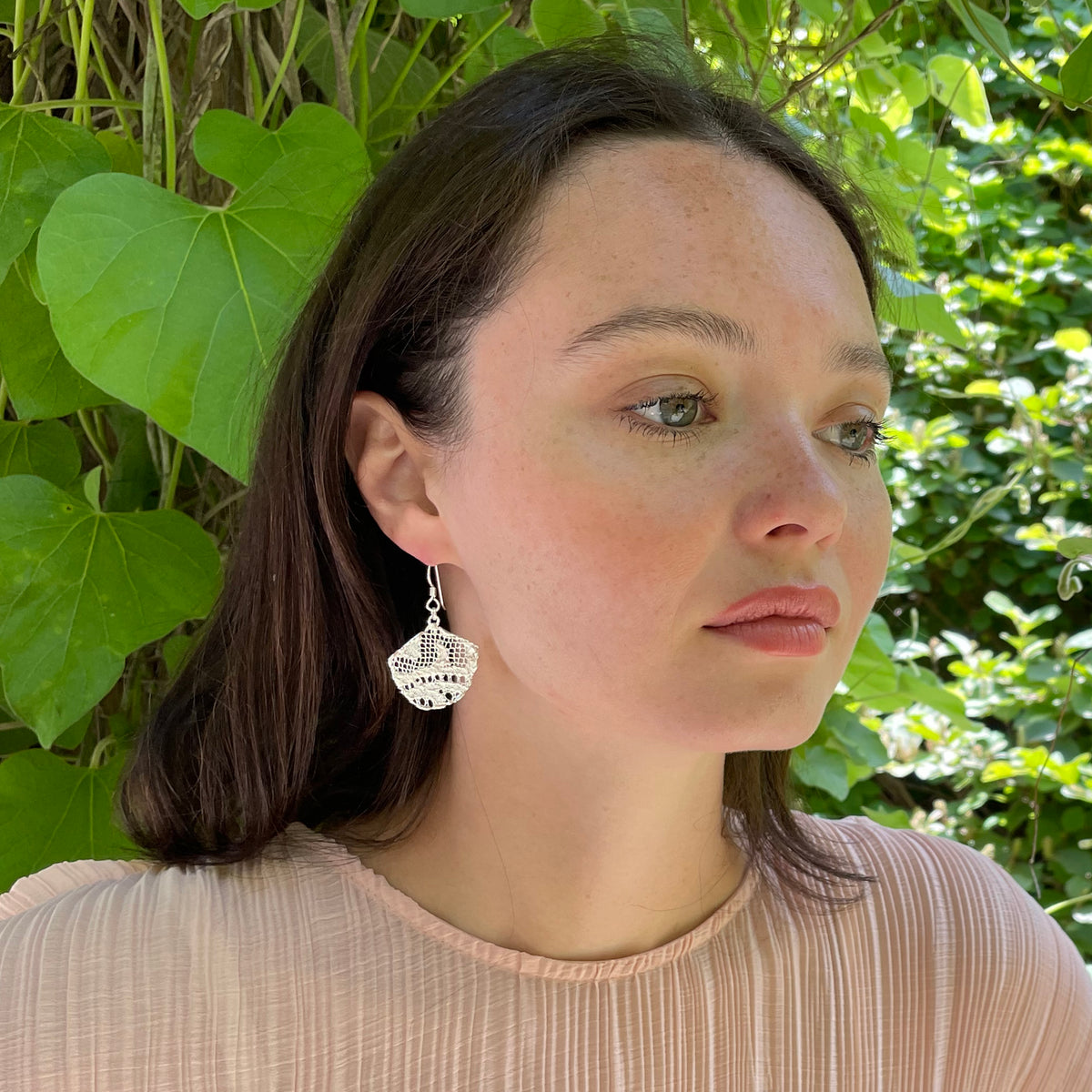 Fan shaped lace earrings in sterling silver on model.