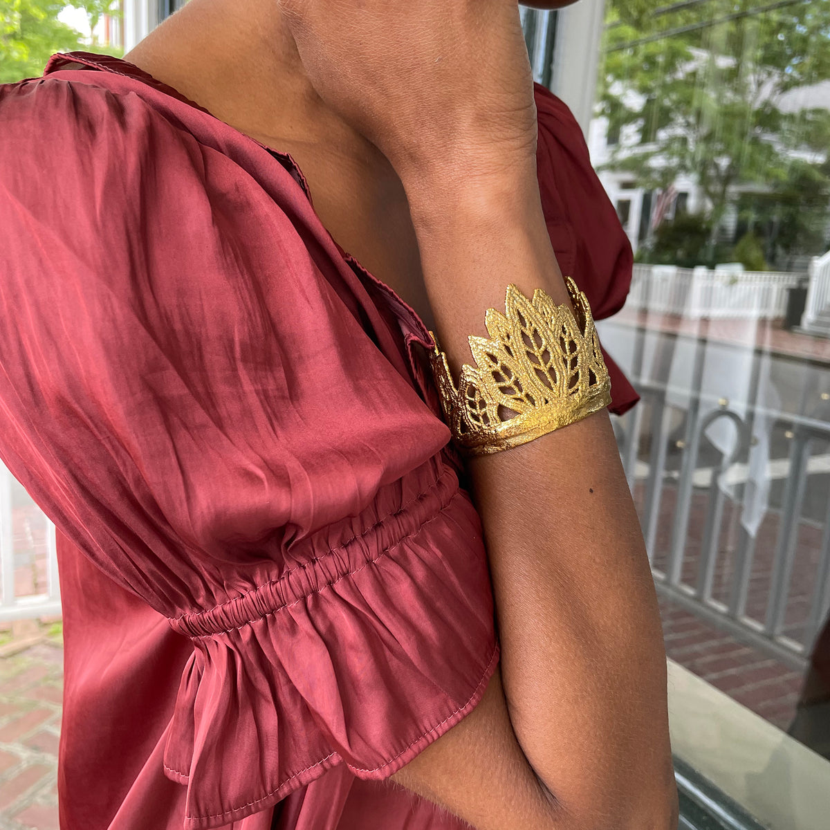Mattie lace cuff bracelet in the shape of leaves dipped in 24k gold on model.