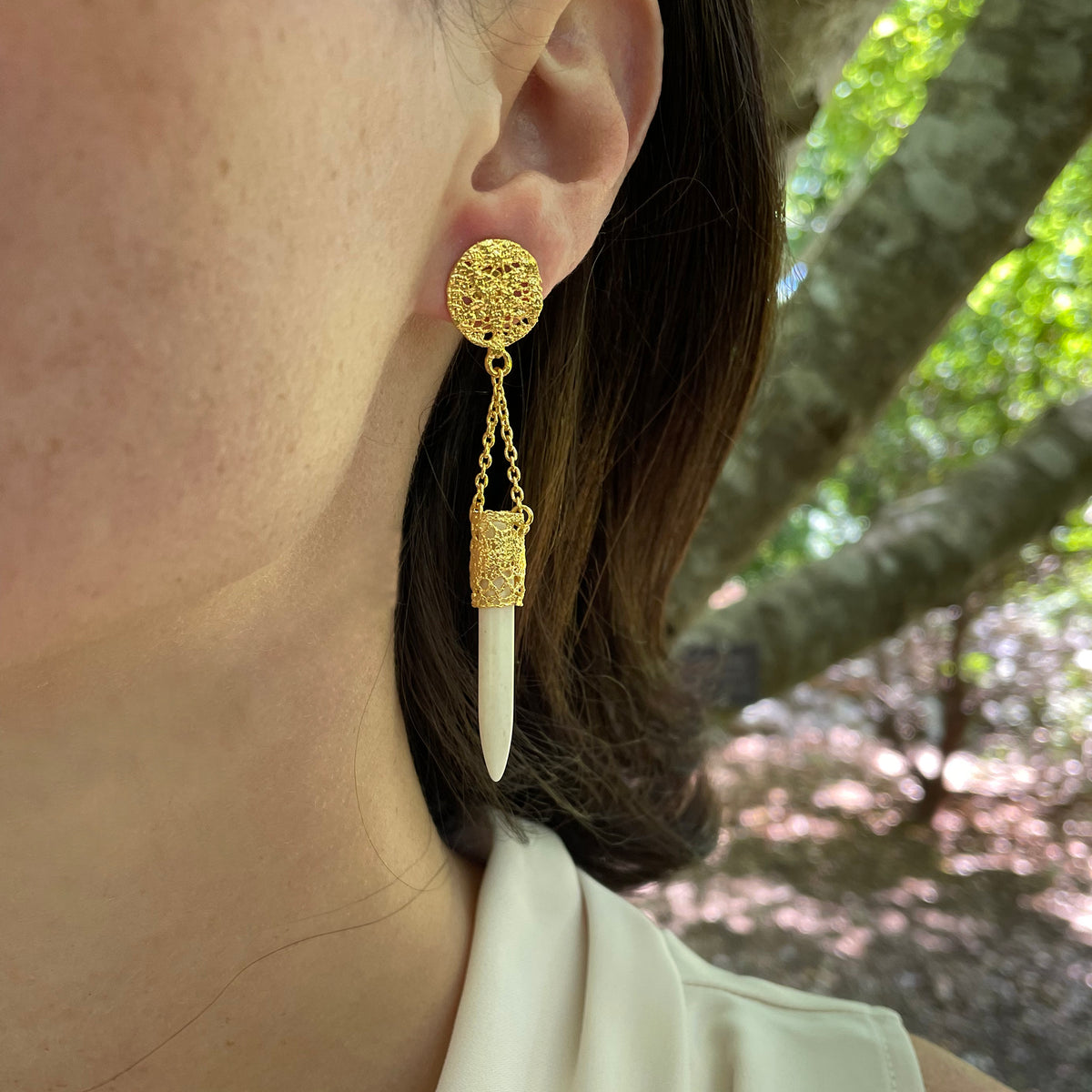 Model wearing chandelier lace earrings in 24k gold with white turquoise wands.