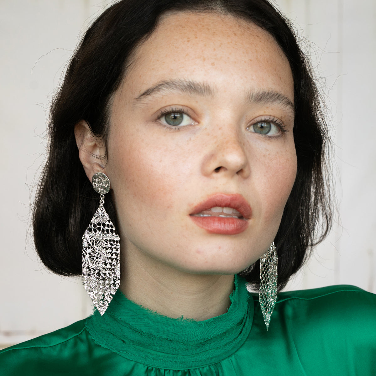 Intricate Dangling Hexagon Earrings made from Chantilly lace in sterling silver worn by a model.