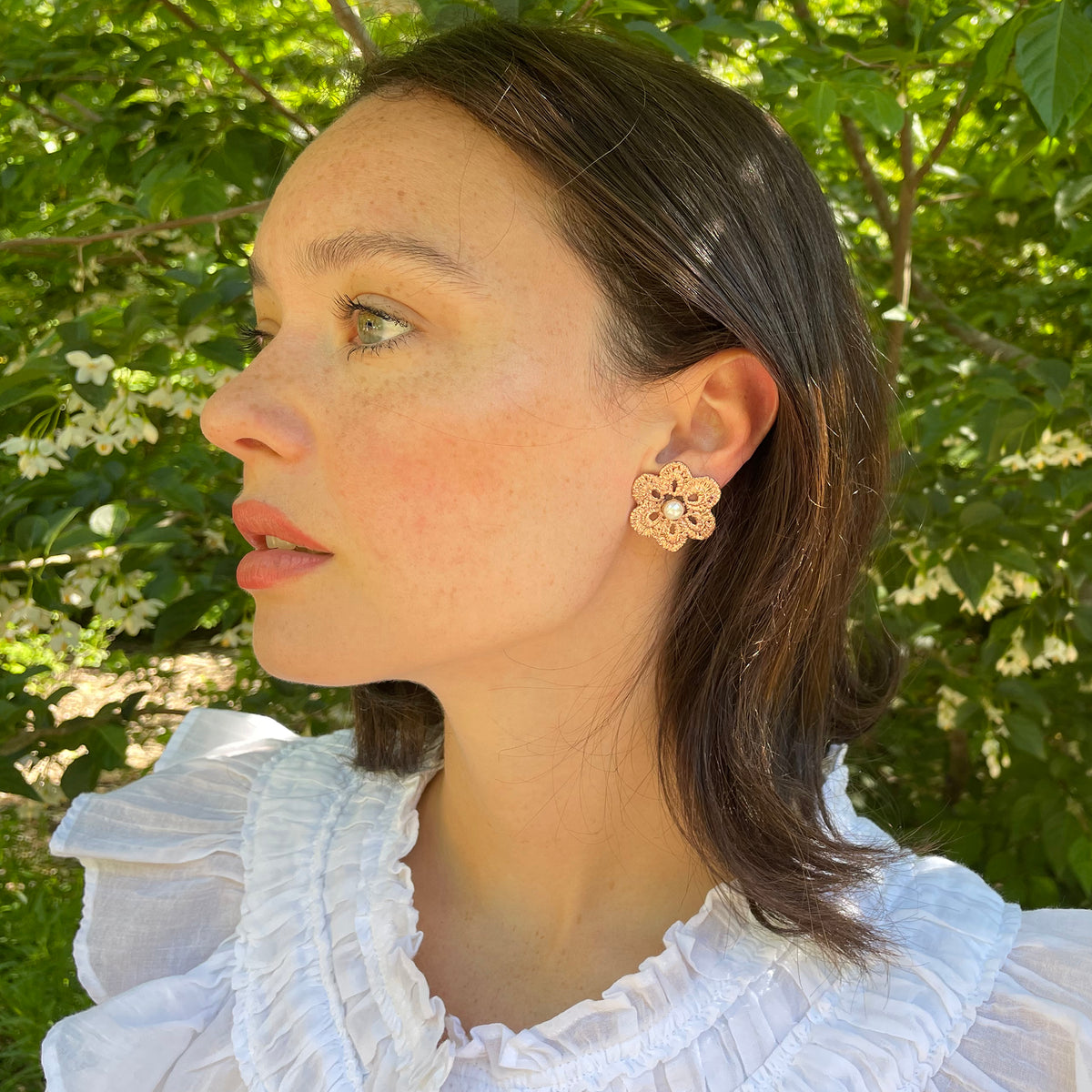 Model wearing pearl stud earrings with lace flower in rose gold.