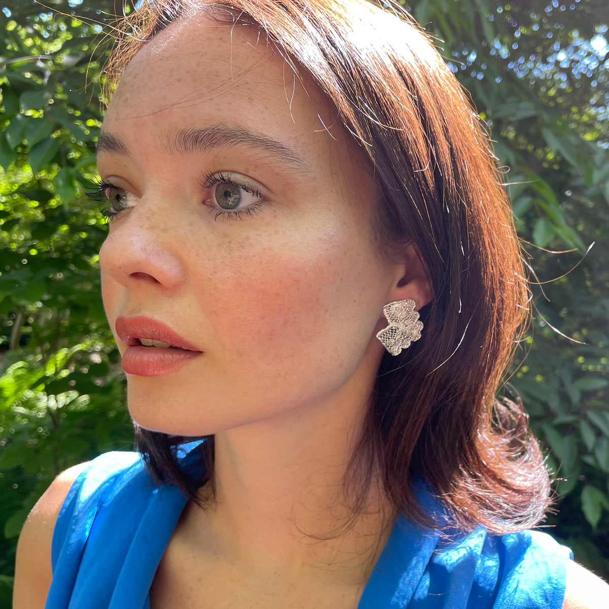 Audra lace stud earrings in sterling silver on model.