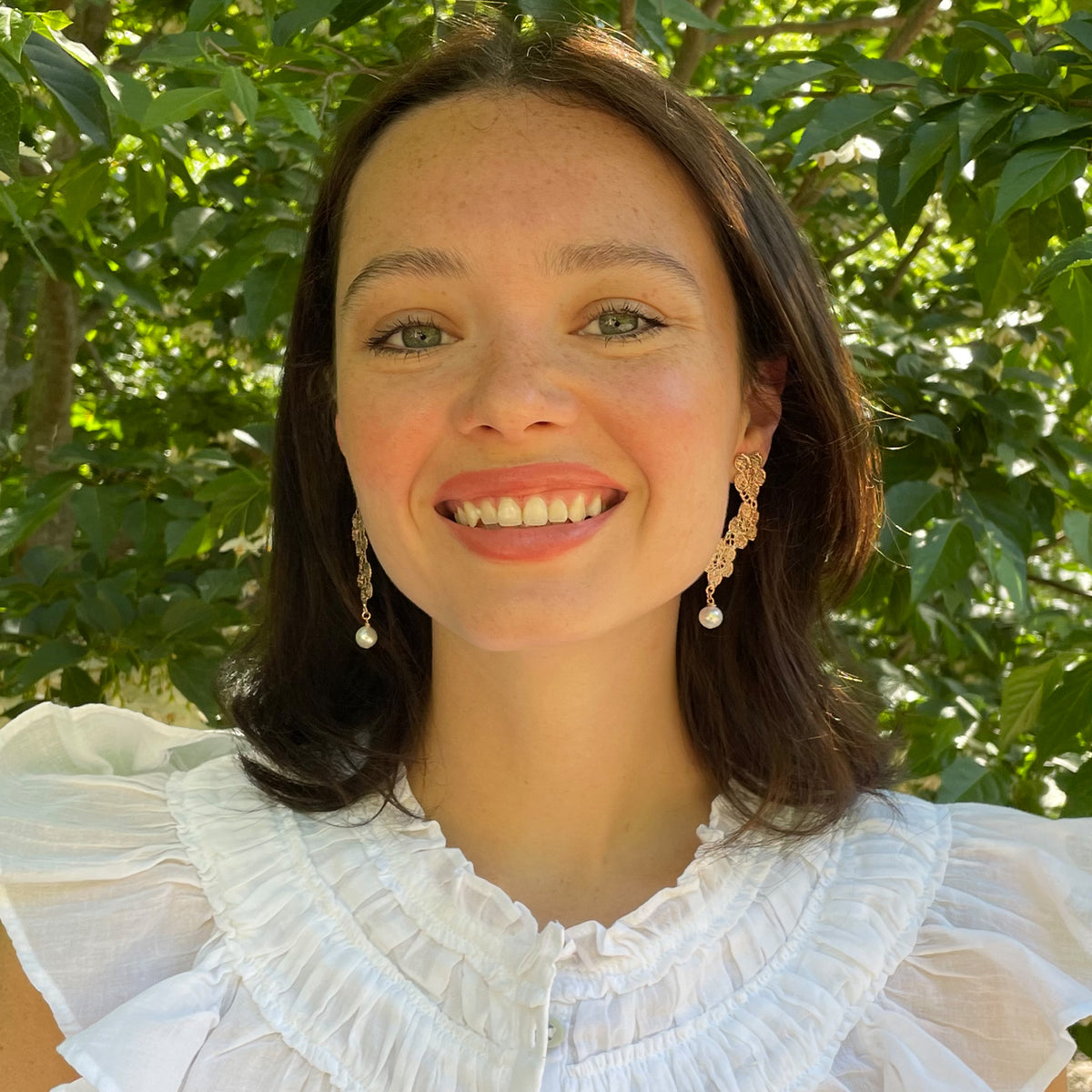 Model showing pearl earrings with lace flower garland dipped in rose gold.