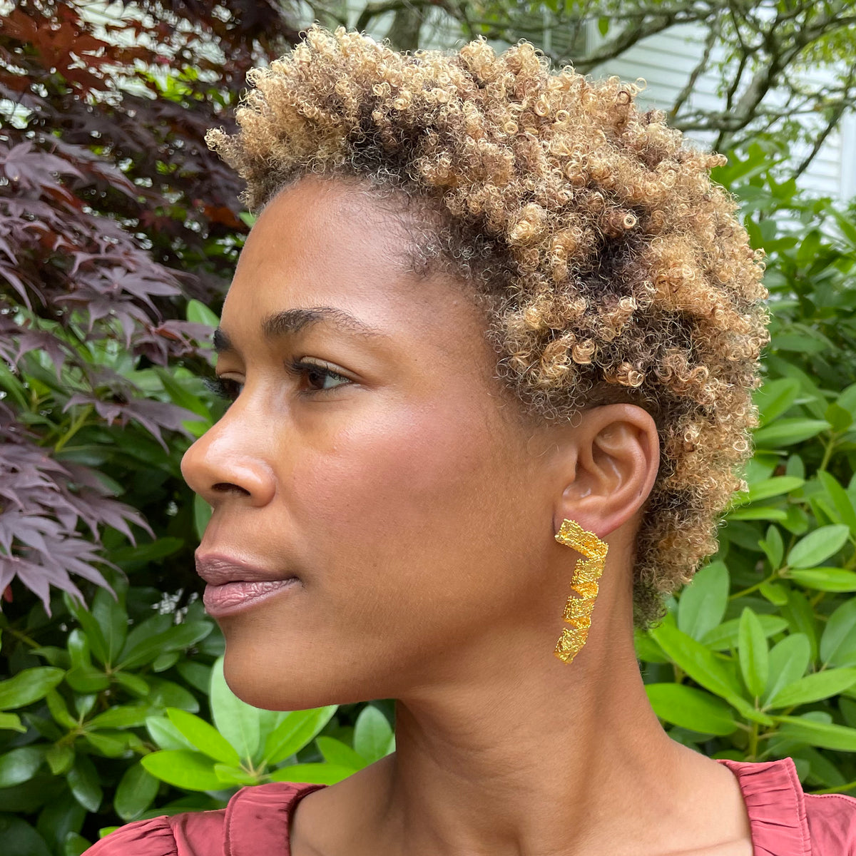 Azeline lace swirl and drop earrings in 24k gold worn by model.
