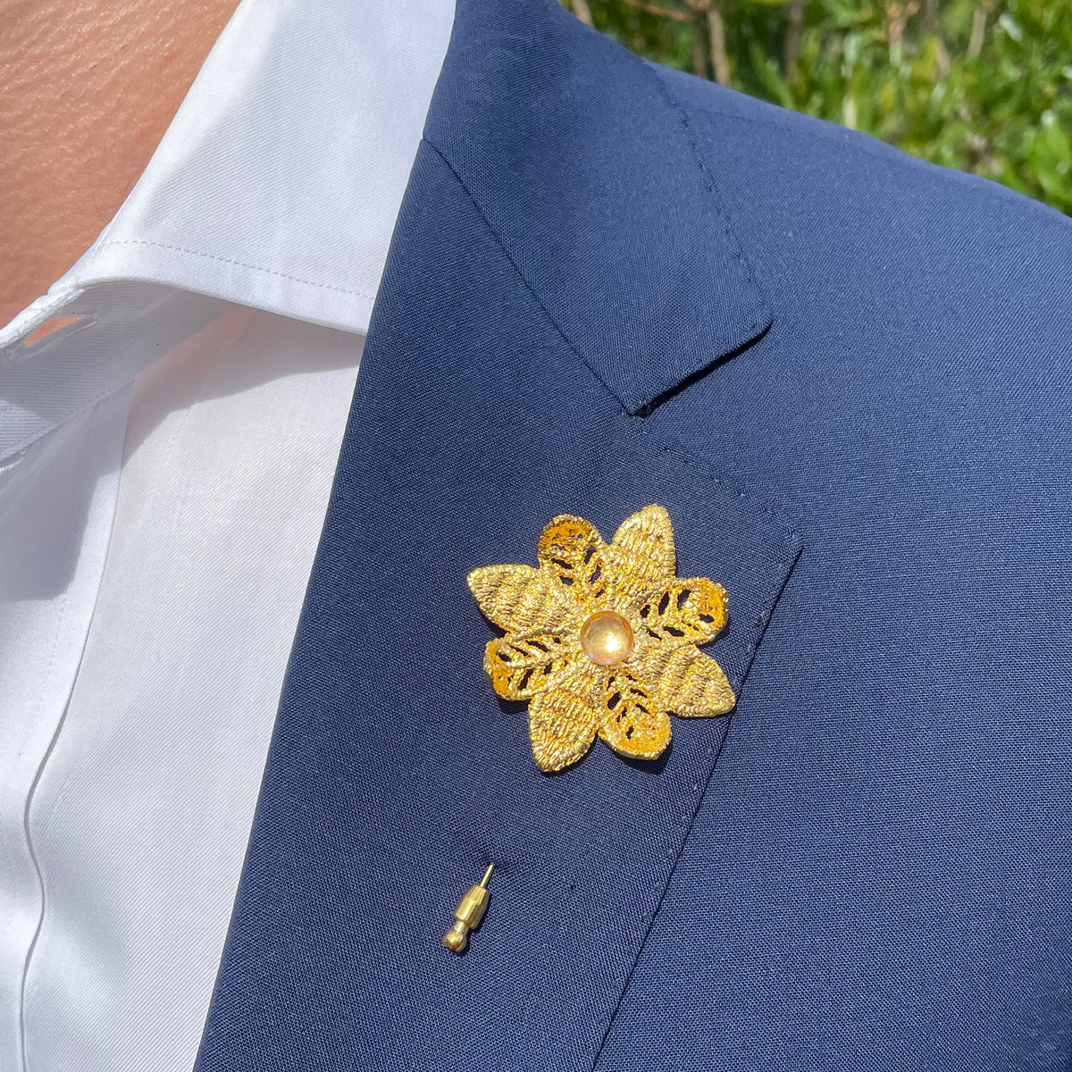 Model wearing Lapel pin 24k gold lace flower with 10mm white Topaz.