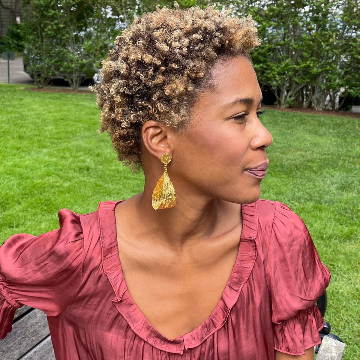 Camie lace loop earrings in 24k gold worn by model.