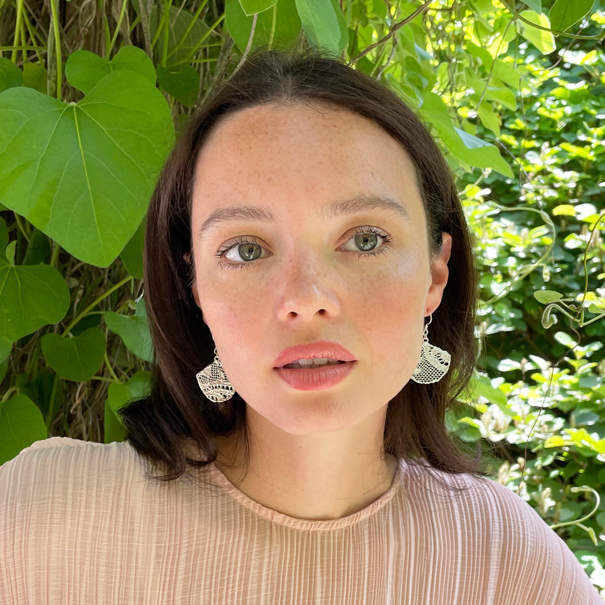 Fan shaped lace earrings in sterling silver on model.
