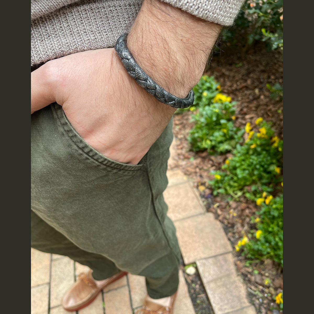 Braided open men&#39;s bangle bracelet in dark oxidized sterling silver on model.