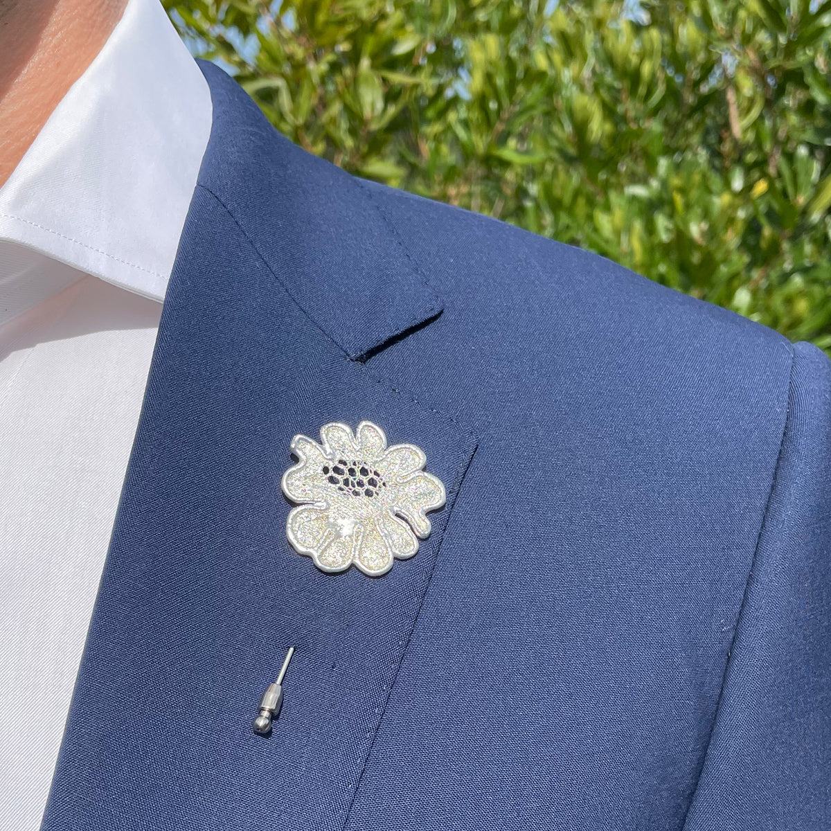 Model wearing Lapel Pin in the shape of a rose made from wedding dress lace dipped in sterling silver.