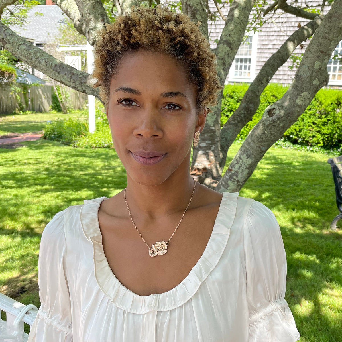 Fine lace rose necklace in rose gold on a model.