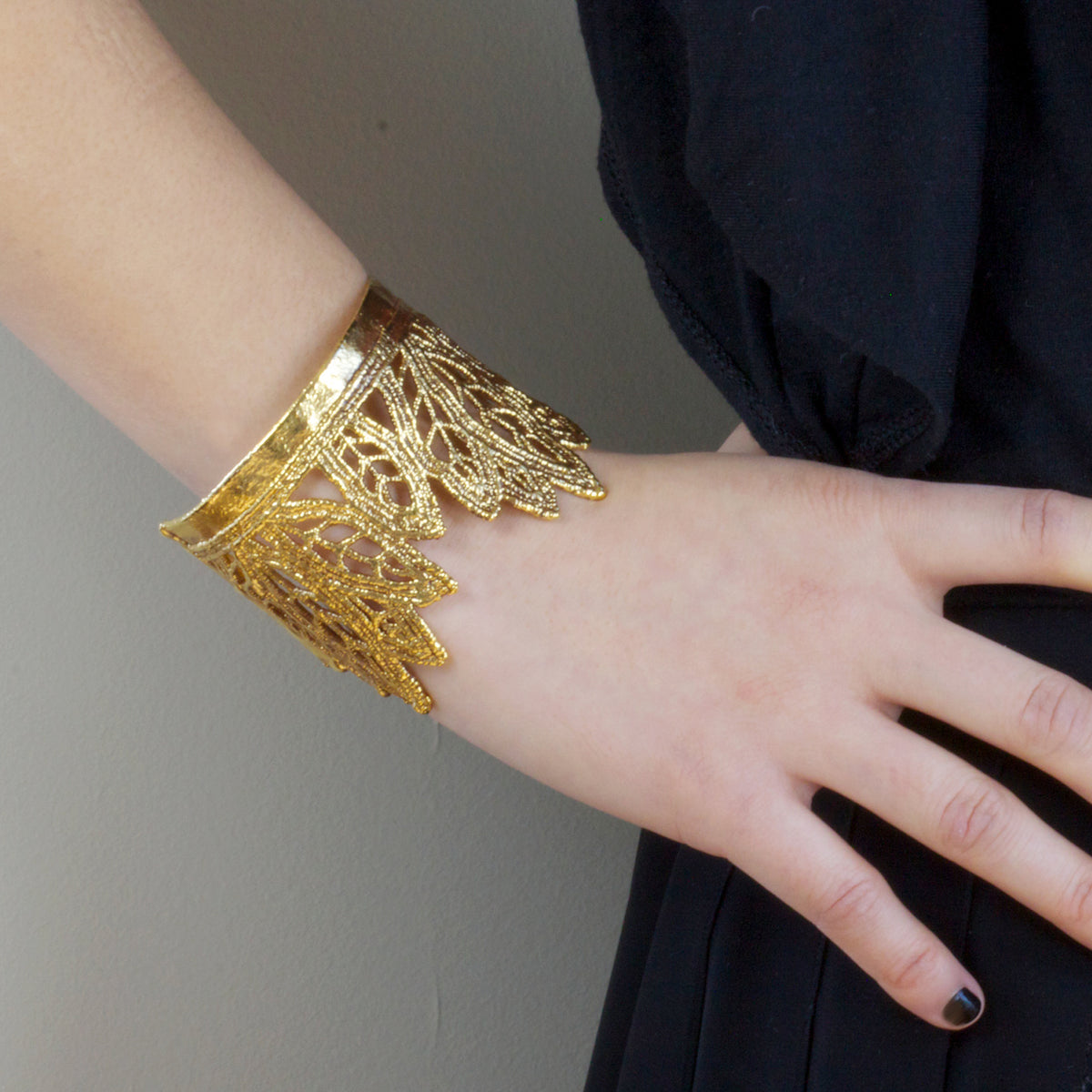 Mattie lace cuff bracelet in the shape of leaves dipped in 24k gold on model.