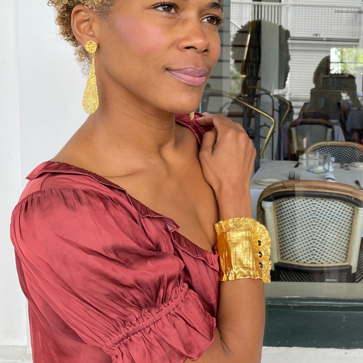 Stunning lace cuff bracelet in 24k gold with three faceted stones worn by model.