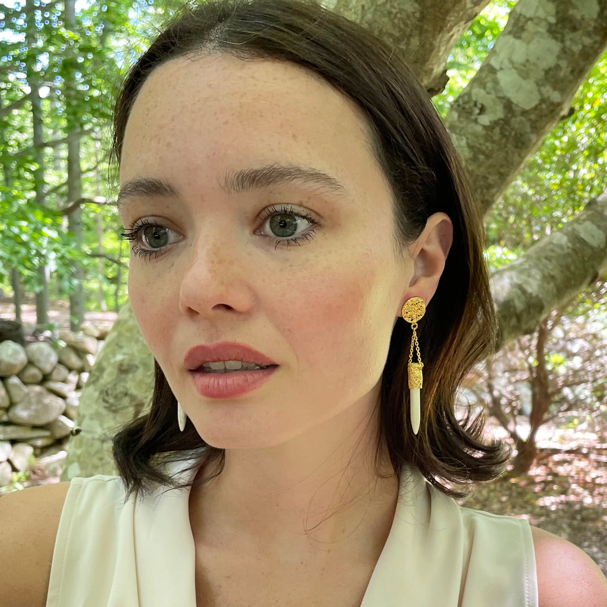Model wearing chandelier lace earrings in 24k gold with white turquoise wands.