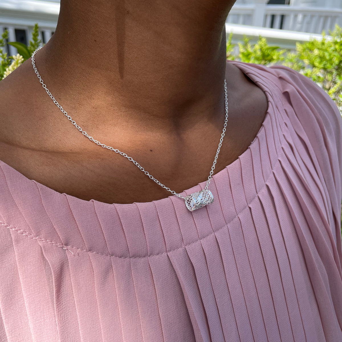 Small lace charm necklace in sterling silver on model.