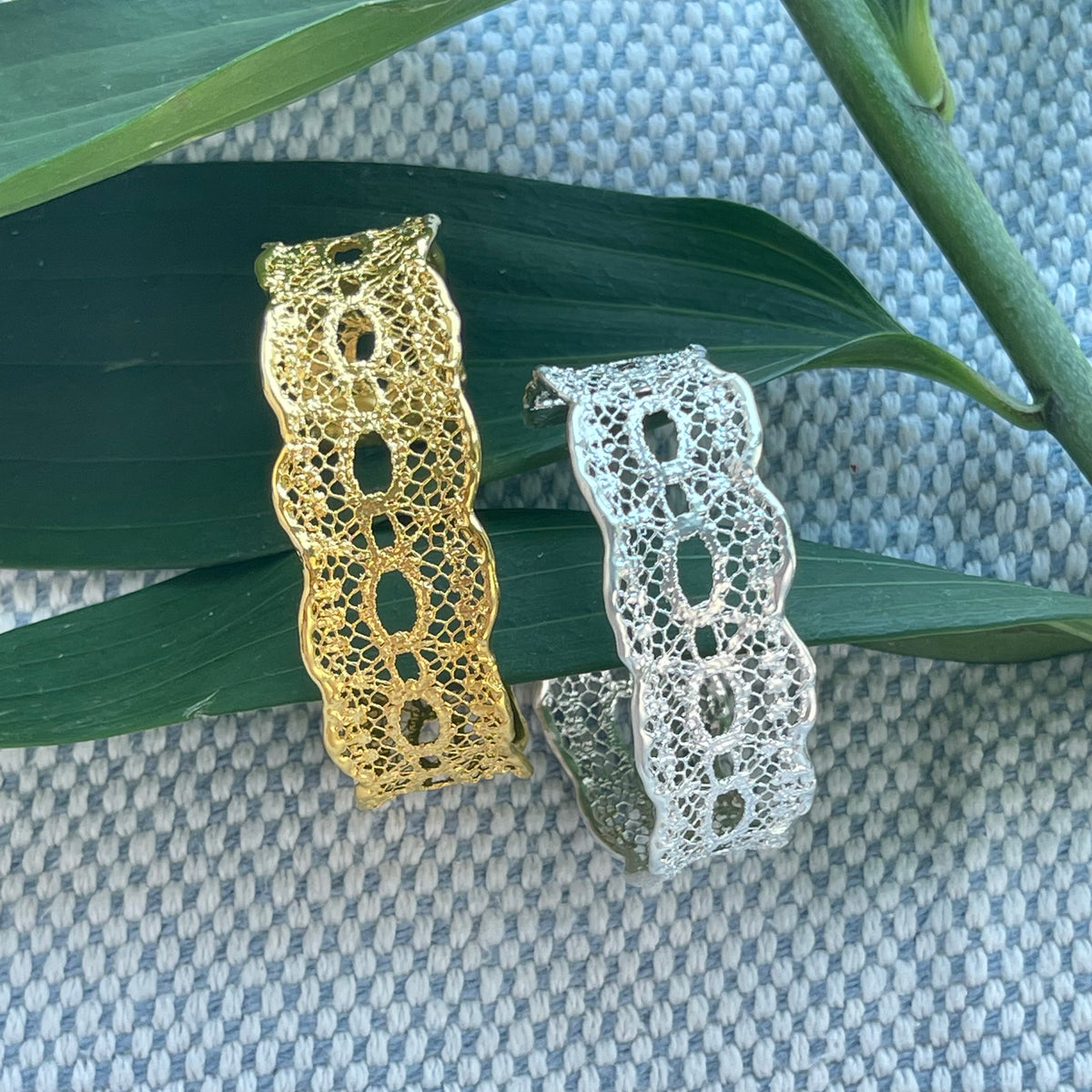 Two Zelia lace cuff bracelets in 24k gold and in sterling silver.
