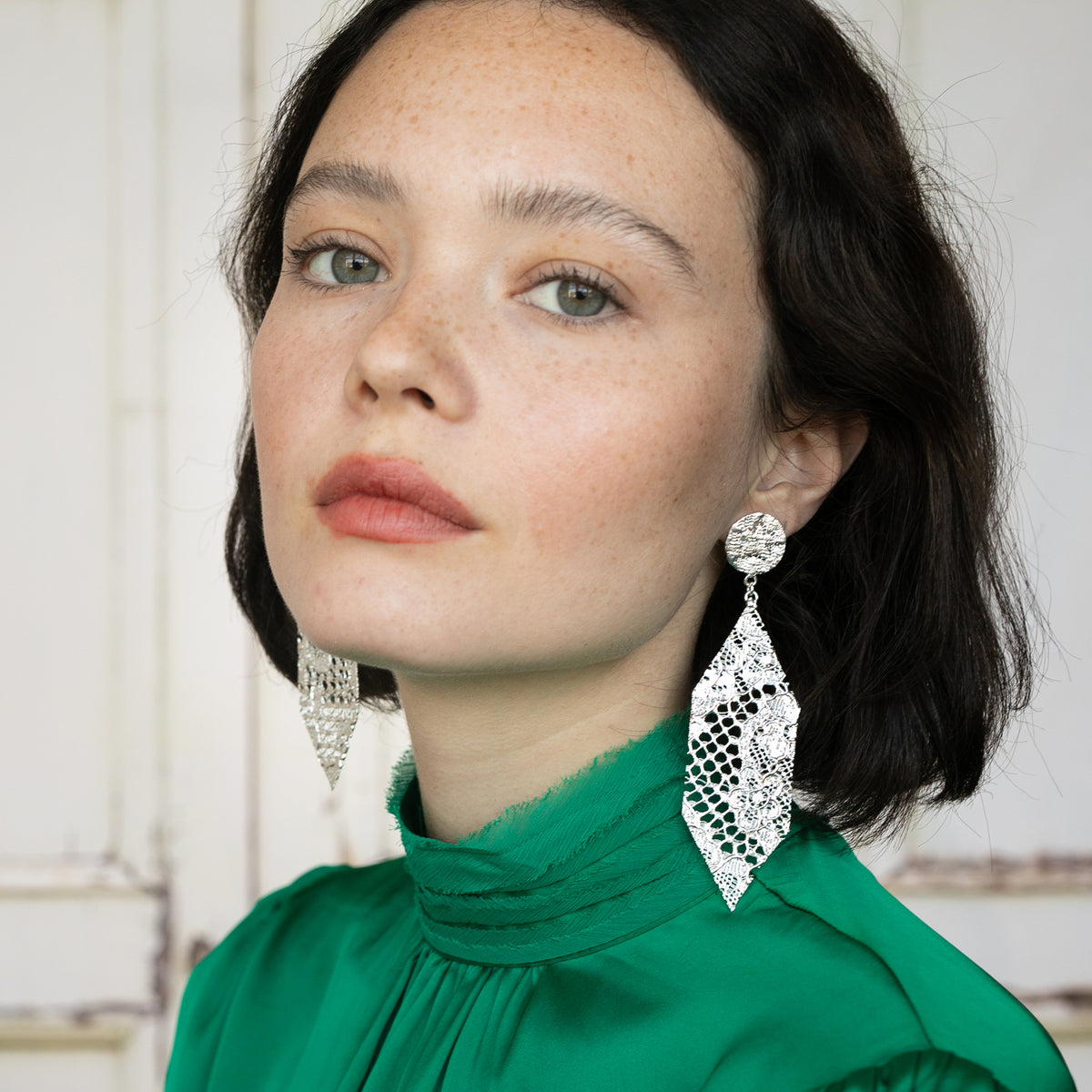 Intricate Dangling Hexagon Earrings made from Chantilly lace in sterling silver worn by a model.