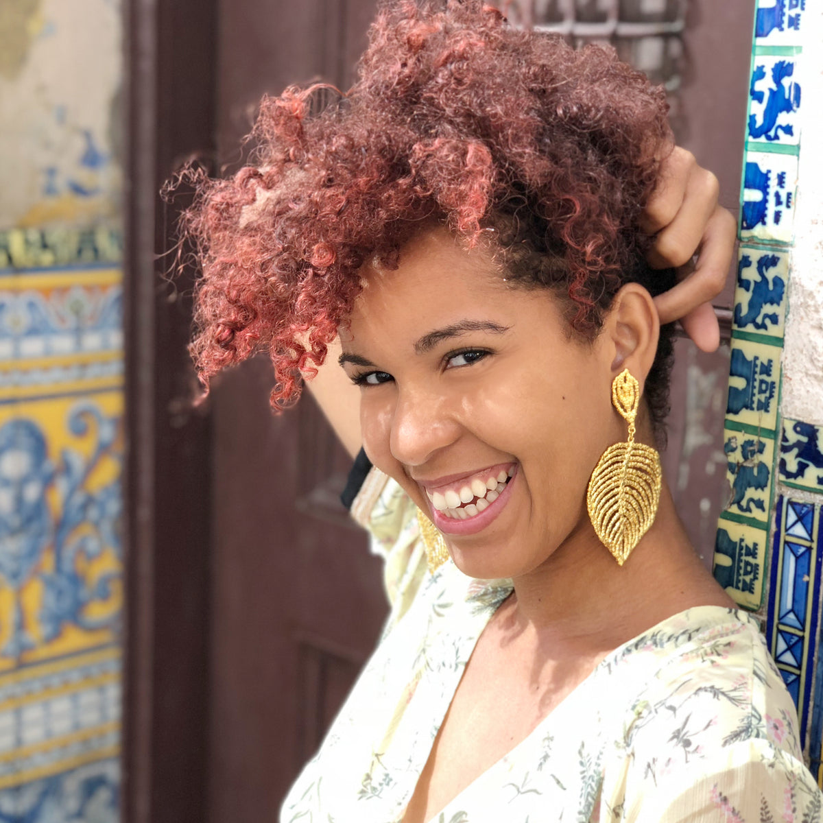 Large lace leaf earrings in 24k gold worn by a model.