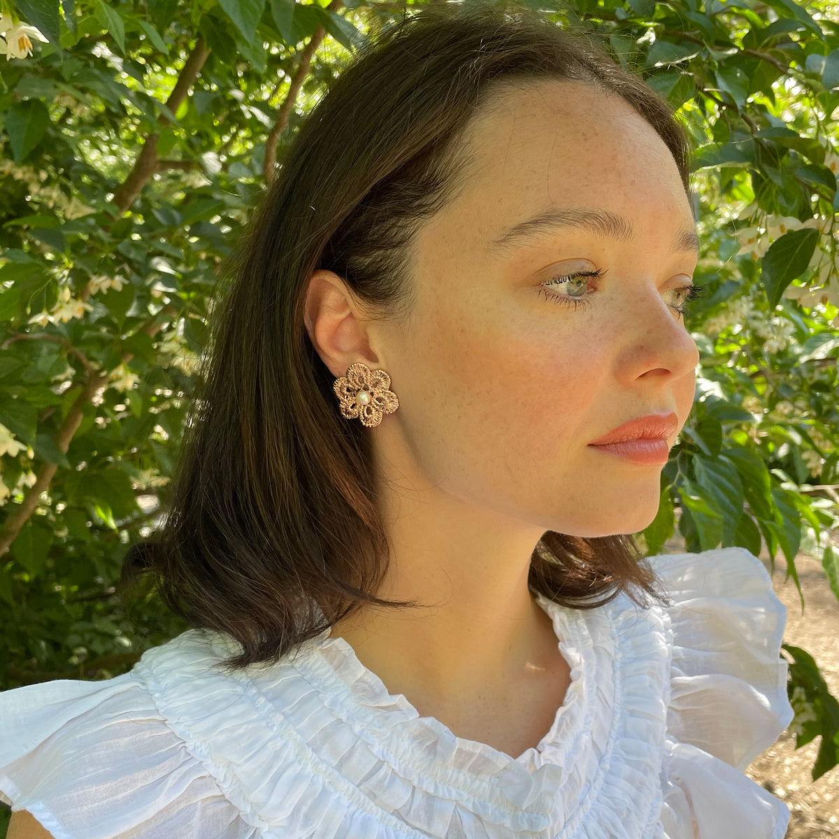 Pearl stud earrings with lace flower in rose gold onm model.