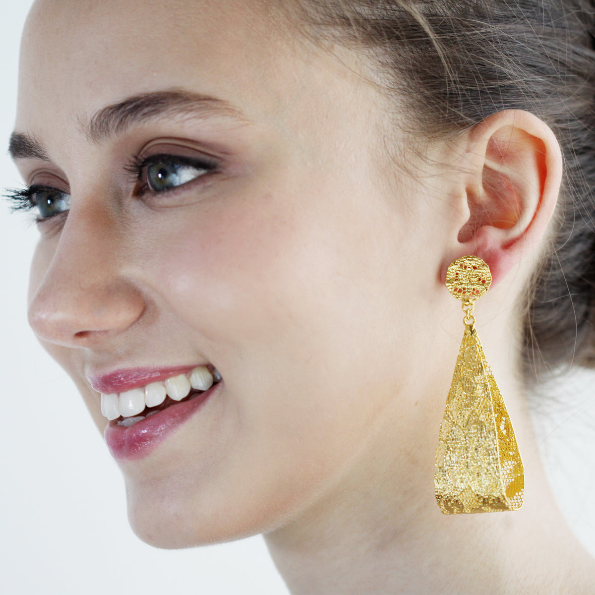 Camie lace loop earrings in 24k gold worn by model.