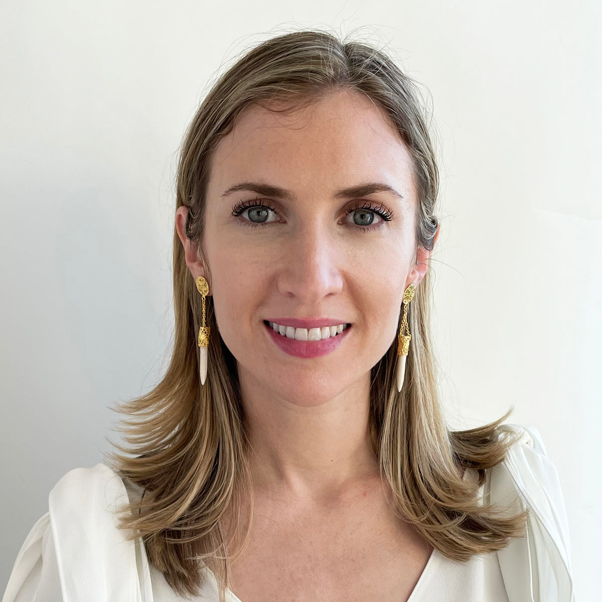 Model wearing chandelier lace earrings in 24k gold with white turquoise wands.