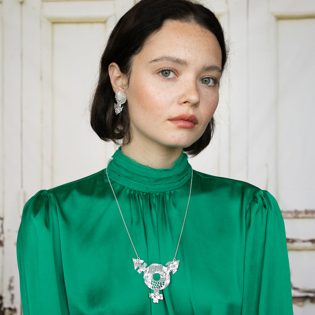 Model with Inclusive Lace Necklace with Female, Male and Non-Binary Symbols. Chantilly Lace dipped in Sterling Silver.