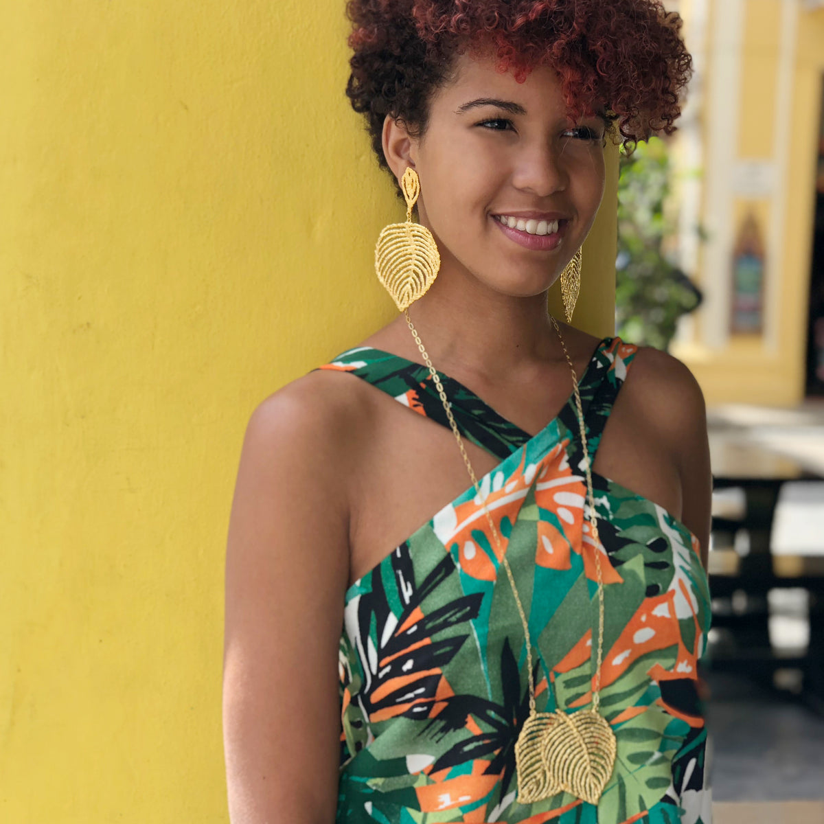 Large lace leaf earrings in 24k gold worn by a model.