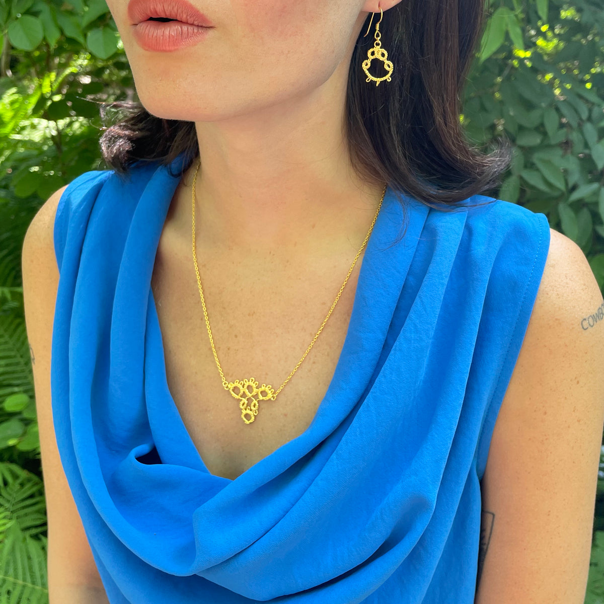 Irish tatted lace pendant necklace in 24k gold on model.