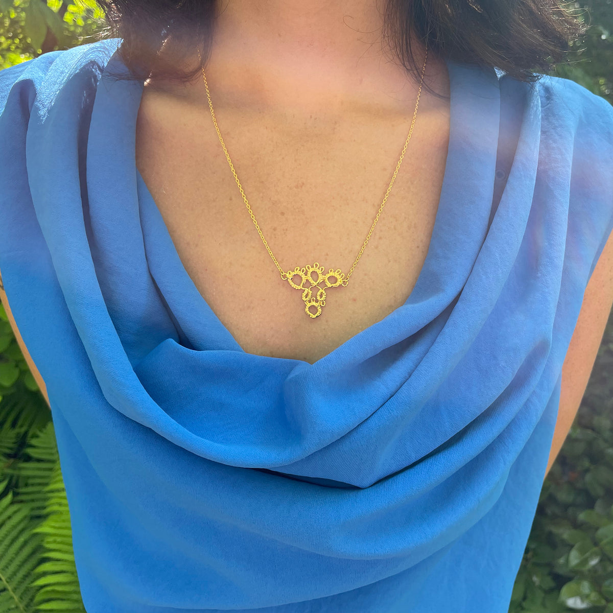 Irish tatted lace pendant necklace in 24k gold on model.