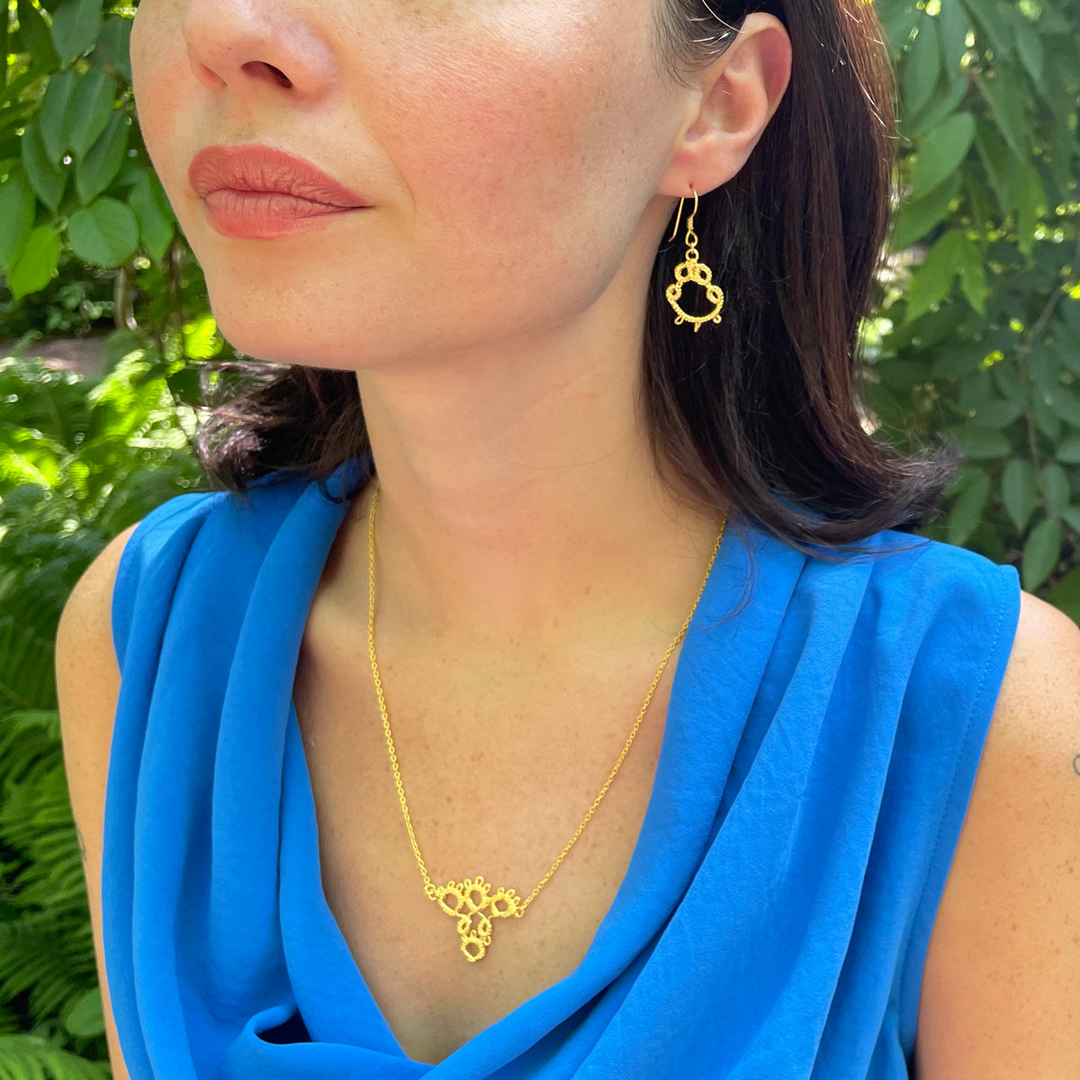 Irish tatted lace earrings in 24k gold worn by model.