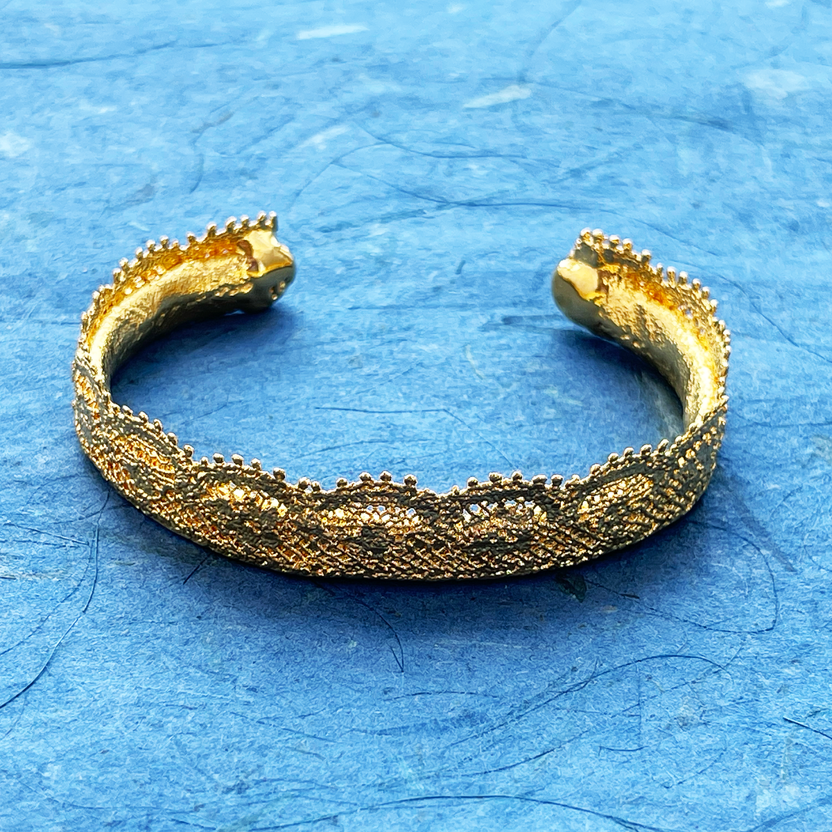 Lace bangle bracelet in 24k gold. Signed and numbered in the back.