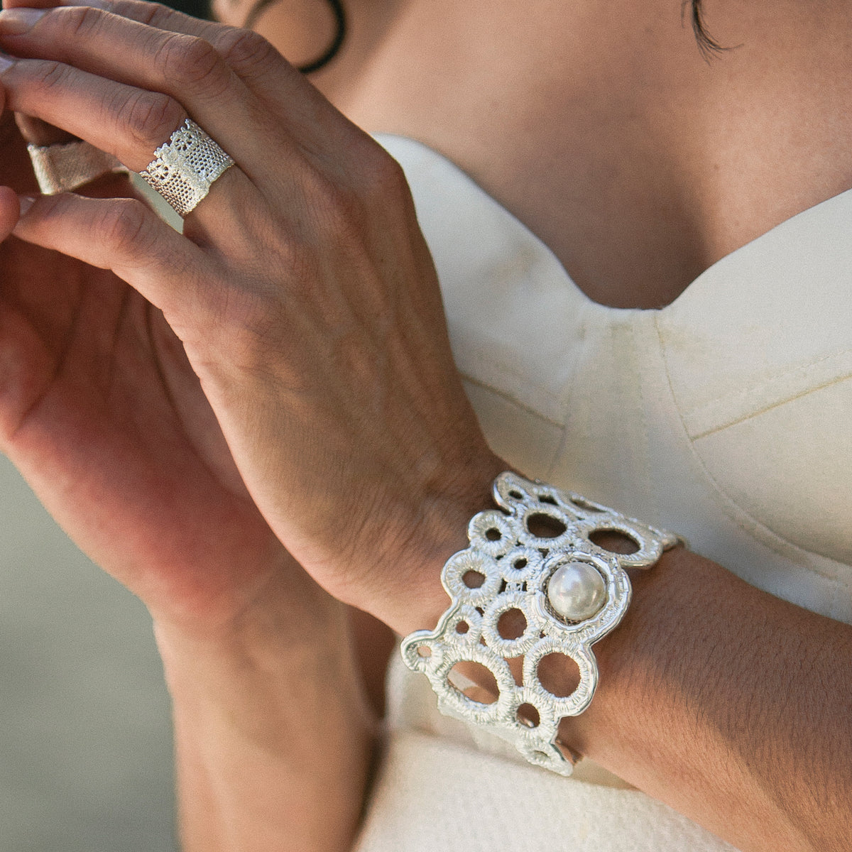 Exquisite lace and  pearl cuff bracelet in sterling silver worn by a model.