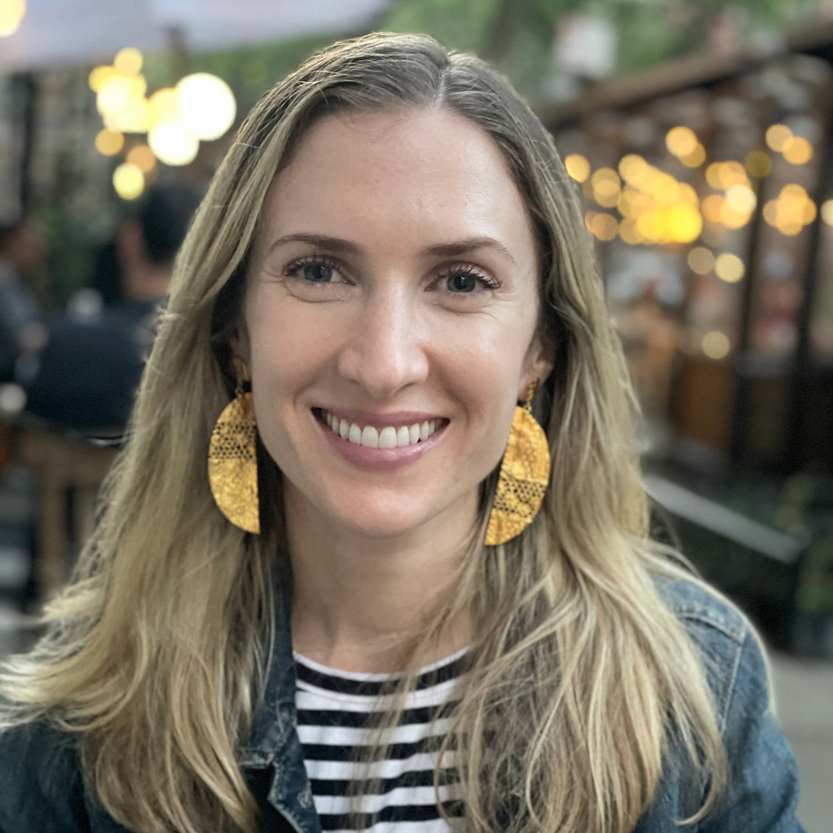 Model wearing half moon lace earrings in 24k gold.