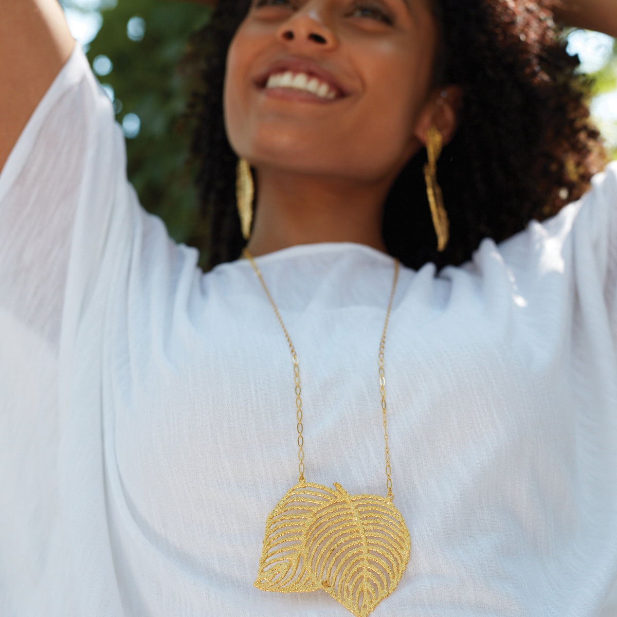 Lace Leaf necklace in dipped 24k gold worn by a model.
