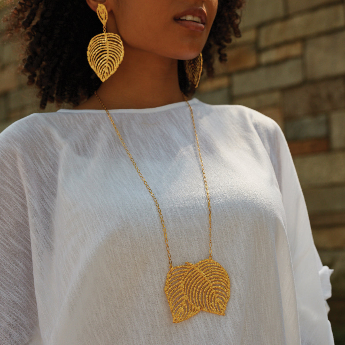Lace Leaf necklace in dipped 24k gold worn by a model.