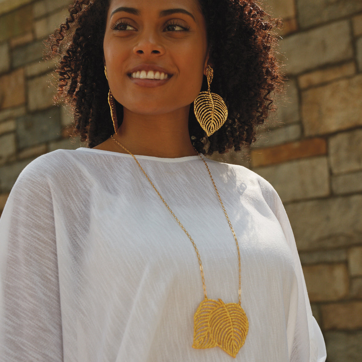 Lace Leaf necklace in dipped 24k gold worn by a model.