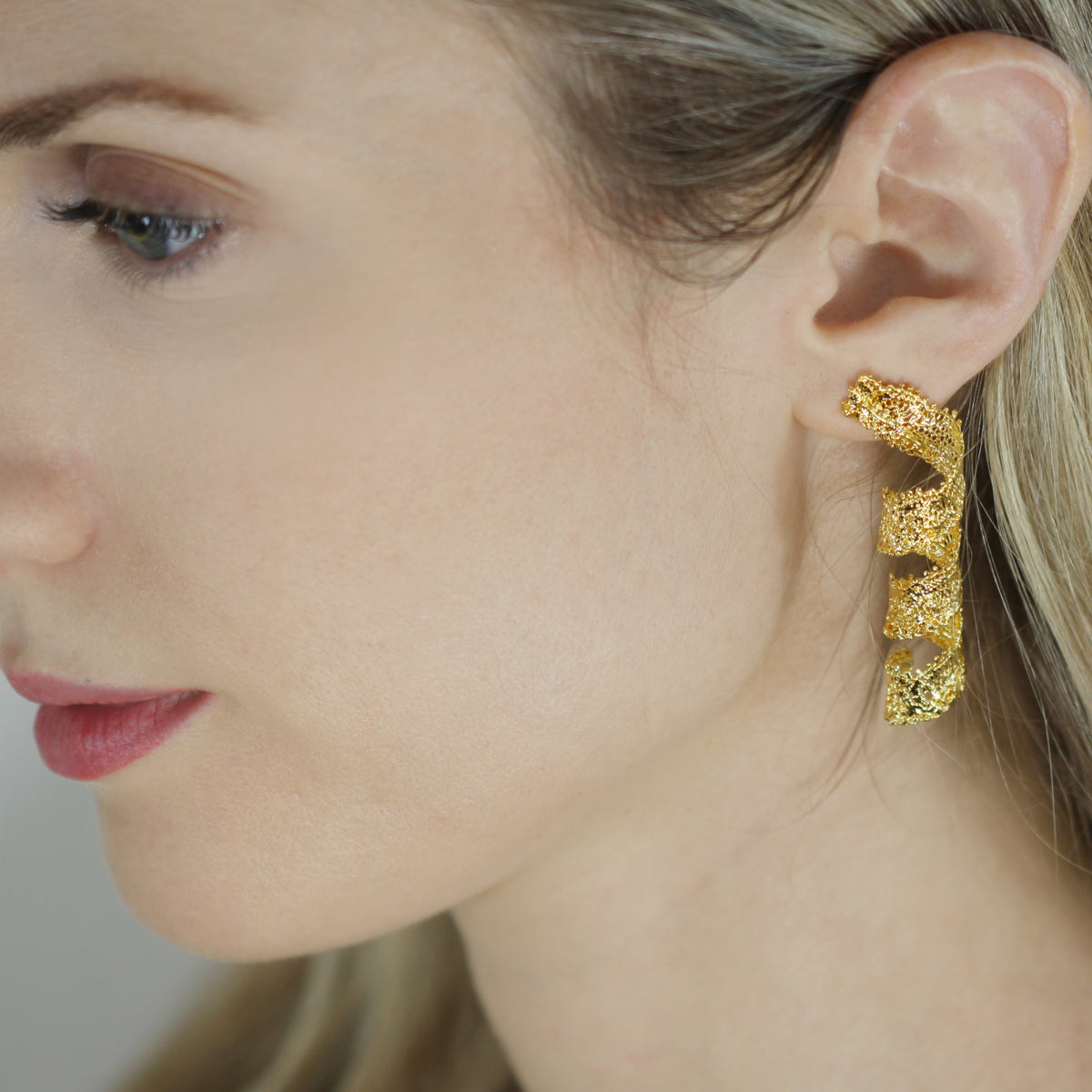 Azeline lace swirl and drop earrings in 24k gold worn by model.